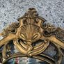 large, ornate gold mirror features a baroque frame Image 3
