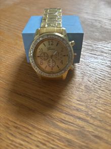 Gold coloured watch with diamonds around the face