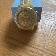 Gold coloured watch with diamonds around the face