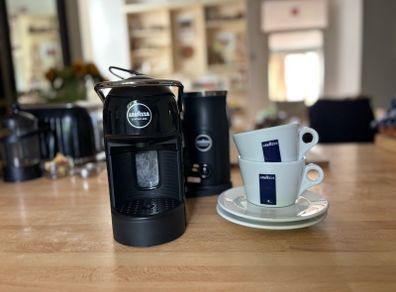Lavazza A Modo Mio Jolie Evo Milk Black coffee machine with 2 lavazza cups and saucers