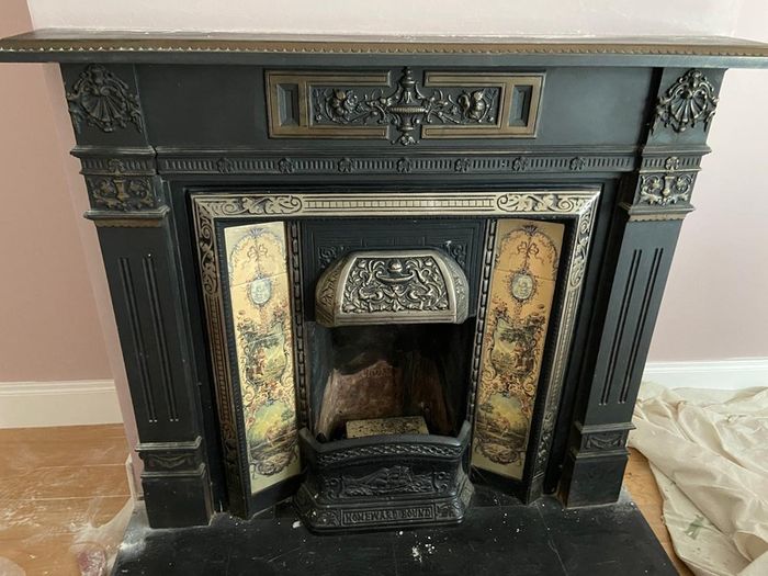 Late Victorian / early Edwardian style cast iron fireplace with tiled inserts and a decorative mantel surround