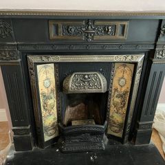 Late Victorian / early Edwardian style cast iron fireplace with tiled inserts and a decorative mantel surround
