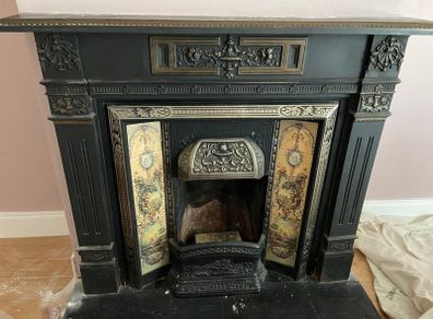 Late Victorian / early Edwardian style cast iron fireplace with tiled inserts and a decorative mantel surround