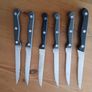 A 12-piece stainless steel steak knife and fork set with wooden riveted handles. Image 4