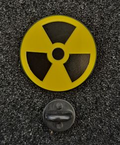 Radiation warning symbol, pin back badge.