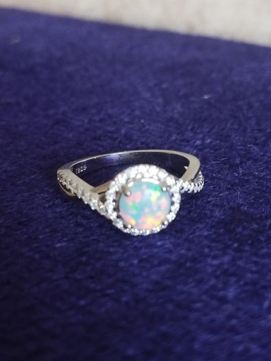 A beautiful 925 silver ring with a white lab opal surrounded by shining cubic zirconia.