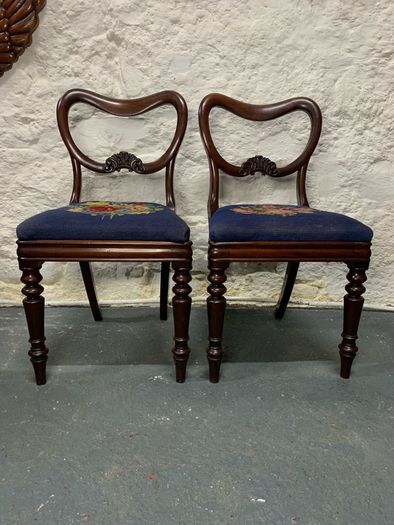 A pair of Victorian mahogany balloon back chairs with tapestry seats.