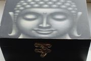 A wooden box with an image of the Buddha's head.