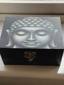 A wooden box with an image of the Buddha's head.