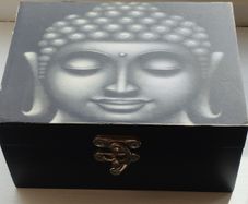 A wooden box with an image of the Buddha's head.