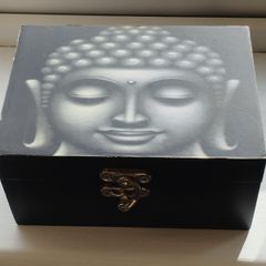 A wooden box with an image of the Buddha's head.