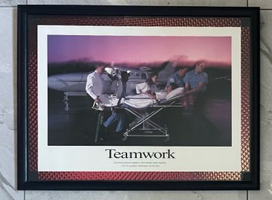 Framed Motivational Teamwork Photo showing ambulance crew/ hospital transporting patient with airplane in the rear