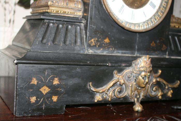 Victorian French Black Slate Mantle Clock (Very large and heavy) with bronze ornamentation Oversized. Open escarpment slate plate Roman numerals. Circa 1890s. Accented with Trojan head. Flanked by two Hellenistic ladies heads on sides. Rose cartouche mask
