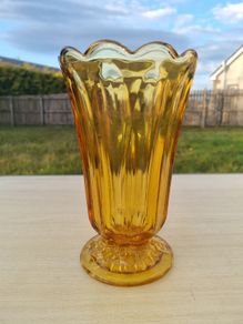 Amber vase on a foot made of pressed glass