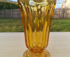 Amber vase on a foot made of pressed glass