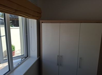 Timer and white wardrobe and bedside locker