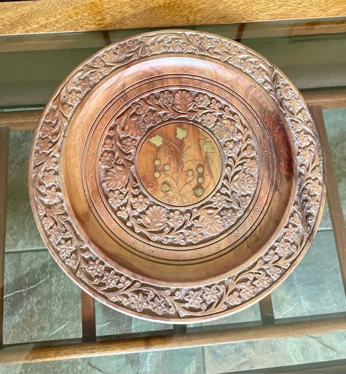 Beautiful vintage hand-carved wooden tray featuring an intricate floral border and a decorative brass inlay geometric star motif in the centre. The craftsmanship is detailed and very tactile, giving this piece a rich, warm character. The tray is solid and