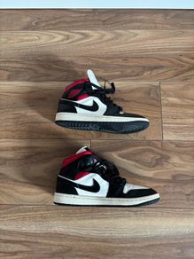 Nike Air Jordan 1 Mid trainers in the classic black, white and red colourway