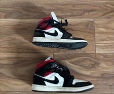 Nike Air Jordan 1 Mid trainers in the classic black, white and red colourway