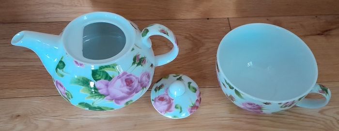 Tea for one: tea pot and cup with rose design on white