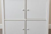 IKEA KALLAX 2x2 storage unit in white, fitted with 4 individual cupboard door inserts.