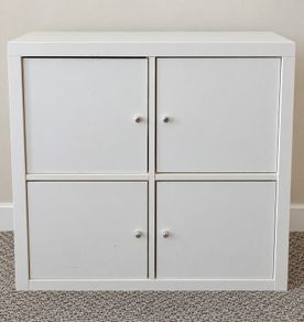 IKEA KALLAX 2x2 storage unit in white, fitted with 4 individual cupboard door inserts.