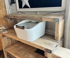 Heavy vintage ceramic basin with a built-in metal rack.