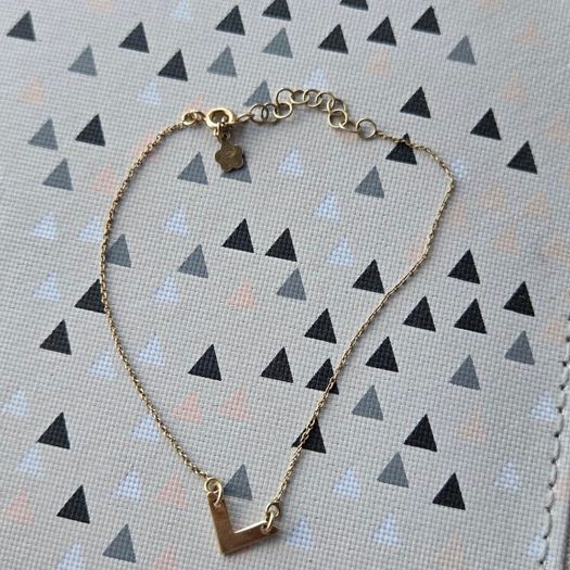 925 sterling silver bracelet with yellow gold plating and V shaped pendant.
