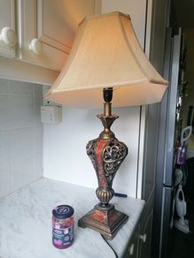 Vintage Tuscan style table lamp with gold-finish resin body with intricate scrollwork and reddish-orange mosaic crackle accents