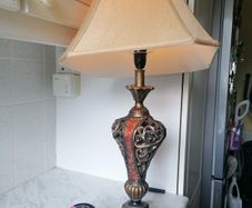 Vintage Tuscan style table lamp with gold-finish resin body with intricate scrollwork and reddish-orange mosaic crackle accents