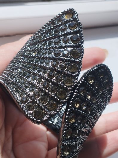 A striking wide bracelet encrusted with sparkling rhinestones.