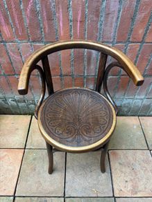 A vintage 1920s Thonet style bentwood chair with armrests.