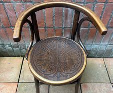 A vintage 1920s Thonet style bentwood chair with armrests.