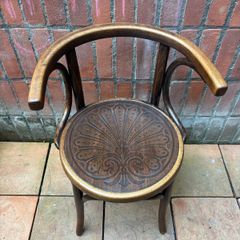 A vintage 1920s Thonet style bentwood chair with armrests.