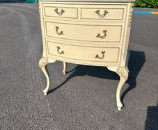 vintage Olympus cream and gilt Louis style chest of drawers featuring bow-front drawers and cabriole legs.
