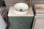 Green bathroom vanity unit with countertop basin and gold tap