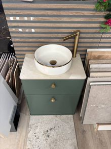 Green bathroom vanity unit with countertop basin and gold tap