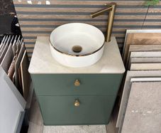 Green bathroom vanity unit with countertop basin and gold tap