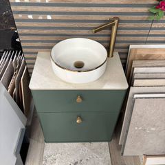 Green bathroom vanity unit with countertop basin and gold tap