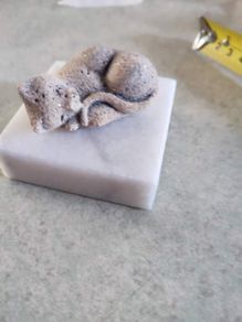 Small cat on marble plinth.