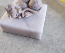 Small cat on marble plinth.