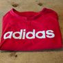 red Adidas t-shirt features a prominent white logo on the chest. Great condition. Image 3