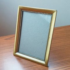 Vintage glazed freestanding gold-toned metal picture frame with classic ornate design size 15x20cm