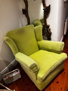 Green high back armchair with arm covers