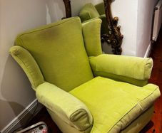 Green high back armchair with arm covers
