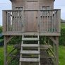 Wooden playhouse with slide and swings Image 4