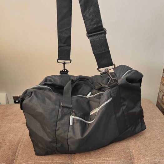 Large black expandable travel bag with shoulder strap