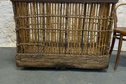 Large Victorian cane and metal laundry basket on wheels.