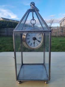 Table clock in a glass lantern.