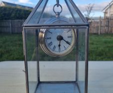 Table clock in a glass lantern.